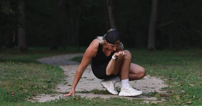 Yoga Practitioner Woman Blonde Performs Parivritta Utkatasana Exercise Variation, Squats on One Leg, Trains in Casual Attire on Park Footpath, Full-Length View