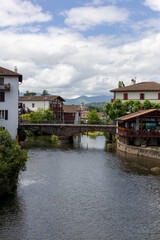 Fototapeta premium Village de Saint Jean Pied de port avec des bâtiments typiques, un pont et une rivière, cité médiévale