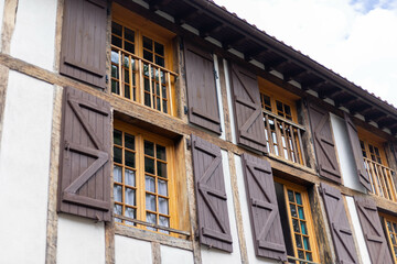 façade d'une ancienne maison en Europe avec des fenêtres et volets en bois