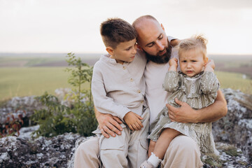 Loving Father Comforting Children Outdoors with Warm Embrace in Nature