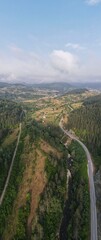 A sweeping landscape reveals rolling hills, meandering rivers, and patches of forest under a cloudy sky, showcasing the beauty of nature at dawn in the serene countryside