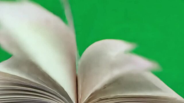 Open book rapidly turns its pages against a green screen background, creating a dynamic visual that symbolizes reading, knowledge, and the joy of literature