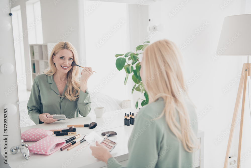 Wall mural Portrait of nice young lady apply blush mirror silky pajama white interior bedroom flat indoors