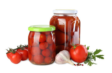 Tasty pickled tomatoes in jars, fresh vegetables and spices isolated on white