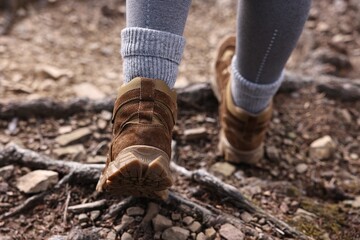 Young hiker in trekking shoes walking outdoors, closeup