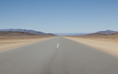 Fototapeta premium Desolate Desert Road Stretching Into Distance with Clear Blue Sk