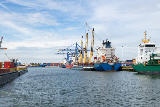 Rotterdam, Netherlands - July 9, 2004: Ships in the cargo terminal in the industrial port of Rotterdam. Cranes load and unload the docked ships.