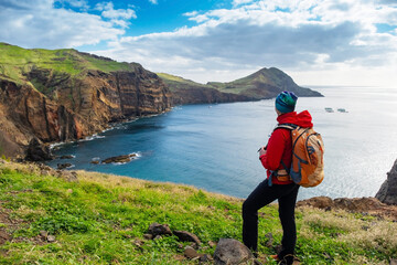 Tourists on hiking path on Ponta de Sao Lourenco Madeira Portugal. Green landscape cliffs and Atlantic Ocean. Ative day, travel background