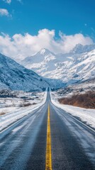 Straight Road Leading to Snowy Mountains Under Clear Blue Skies