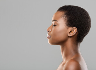 Natural beauty concept. Side view portrait of young beautiful afro woman with flawless skin...