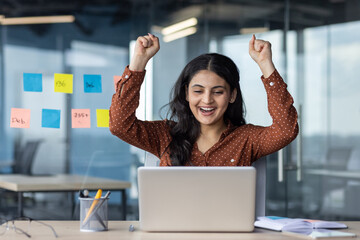 Successful business woman celebrates triumph and victory, woman at workplace received a positive...