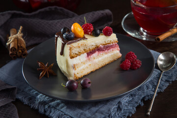 Delicate and delicious cake with butter cream and berries on a dark background