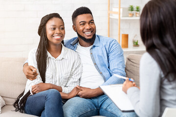 Happy black couple sitting in counselor's office after successful marital therapy, copy space