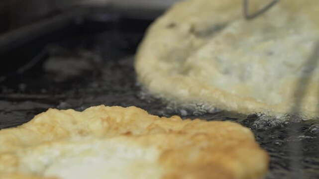 Fried flatbread (L&aacute;ngos in Hungarian language) frying in oil.