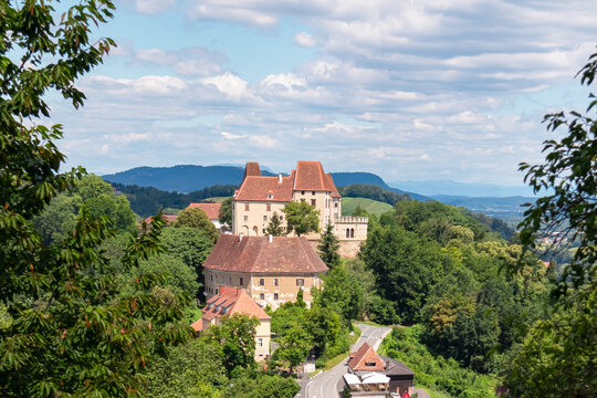 Panoramic view of historic Seggau castle on hill Seggauberg in Leibnitz, south west Styria, Austria, Europe. Idyllic landscape with trees and rolling hills. Peaceful serene atmosphere in summer