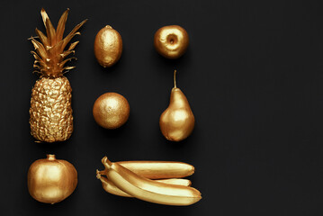 Golden fruits collage on black background, copy space