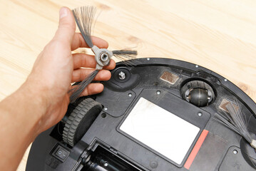 dirty round robot vacuum cleaner with dirty brushes wrapped in hair