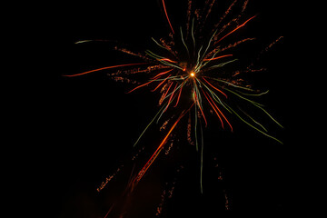 The explosion of fireworks that produces beautiful colorful lights in the dark sky. New Year's Eve celebration moment