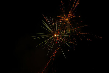 The explosion of fireworks that produces beautiful colorful lights in the dark sky. New Year's Eve celebration moment