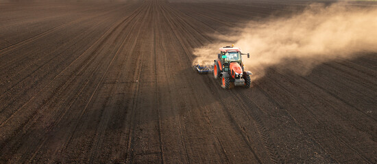 A red tractor prepares the land with a plow. © Dusan Kostic