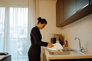 the hotel manager is inspecting the cleaner's work quality by checking into all the  details of the rental airbnb service apartment 