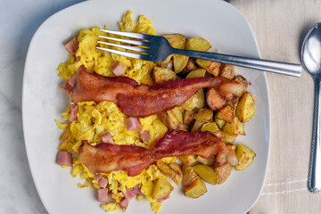 scramble eggs with diced spam with home fries and bacon