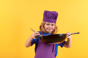 Kid cook with cooking pan. Chef child preparing healthy food. Studio portrait of child with chef...