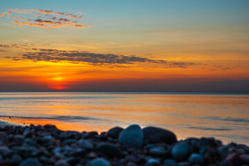 Sandy beach with pebbles of Baltic Sea on Curonian Spit at sunset. Kaliningrad region. Russia