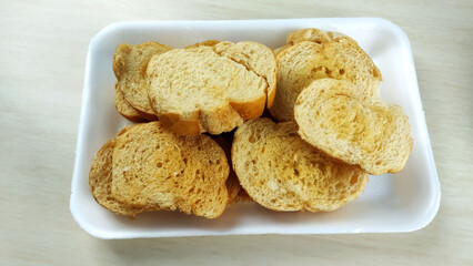  Buttered toasts made of salt french bread on the plate.
