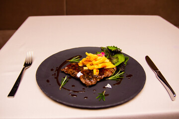 a plate with meat meal and salad decoration on a table