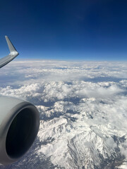 Elevated Panorama: Snow-Covered Mountains and Clouds Viewed from an Airplane