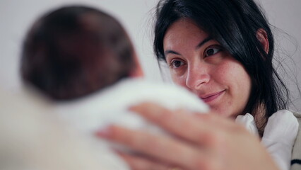 Mother gazes lovingly at her newborn, holding the baby close. The expression on her face reflects...