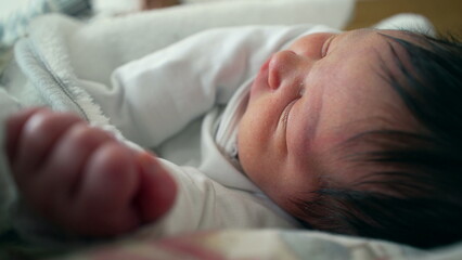Newborn baby resting peacefully, with a focus on the delicate hand near the face. a serene moment of sleep, reflecting the innocence and tranquility of early childhood
