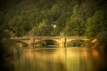 Steinbogenbr&uuml;cke vor Wald an H&uuml;gel mit Wohnhaus von  Morgensonne beleuchtet in Neckartenzlingen