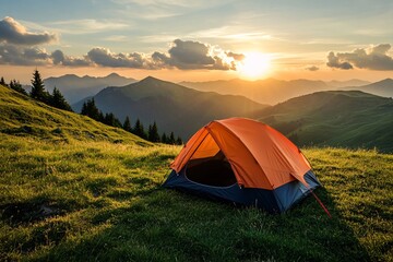 A vibrant orange tent sits on lush green grass with mountains in the background during a breathtaking sunset in a serene camping location