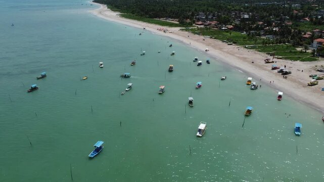Several boats on a blue water beach on the coast of Brazil