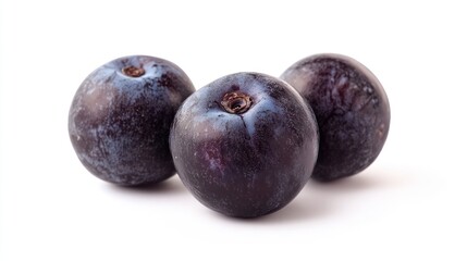 Obraz premium Three dark purple plums arranged on a white background.