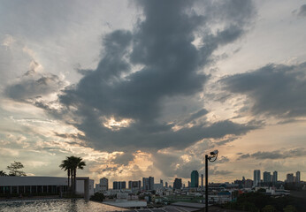 Naklejka premium View of skyscrapers and dramatic sky before sunset. Beautiful clouds in the sky over large metropolitan city of bangkok, Copy space, Selective focus.