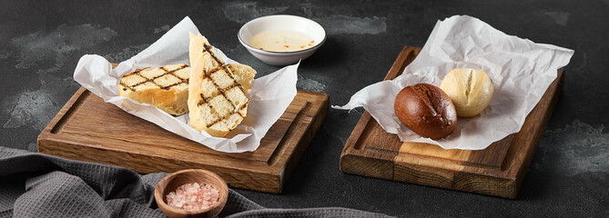 Artistic Bread Assortment on Wooden Boards with Rustic Lighting and Neutral Colors