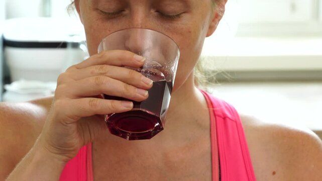Woman drinks juice at the kitchen