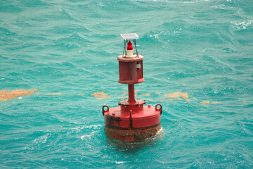A red buoy floats in rough turquoise water in Nassau, Bahamas