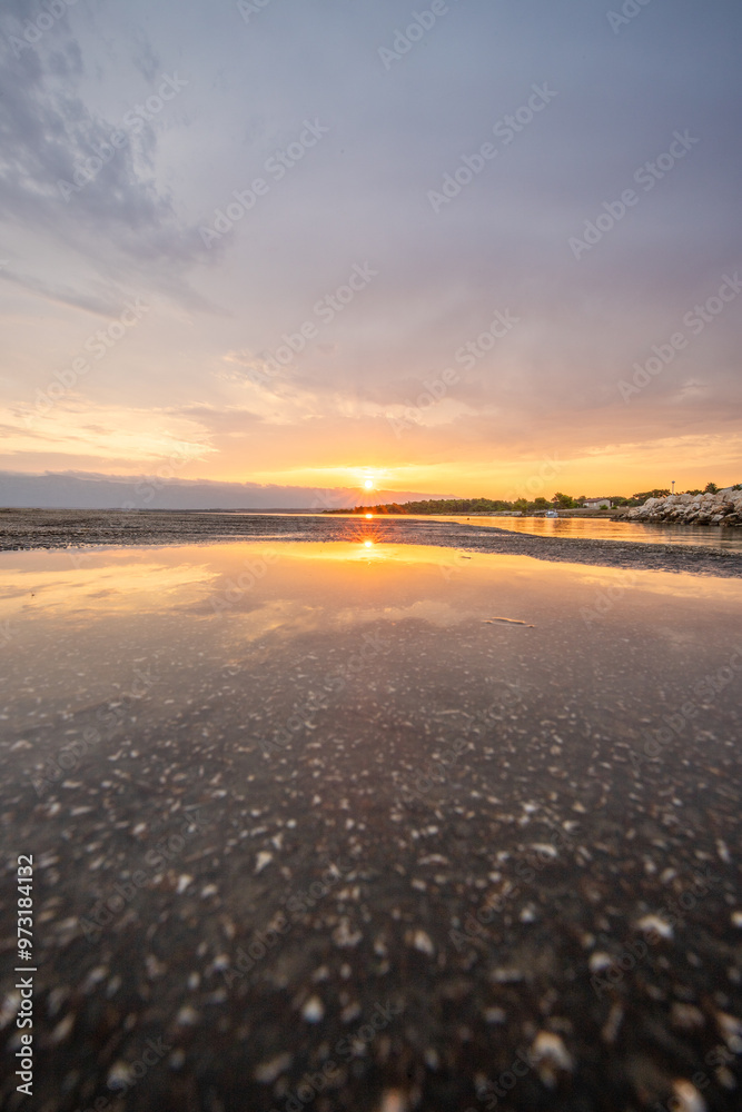 Poster Beach in the morning. Sunrise, pebble beach on a rocky coast. The sky is reflected in the water of a bay. Natural spectacle of a Mediterranean landscape, island of Vir, Zadar, Dalmatia, Croatia, Adria