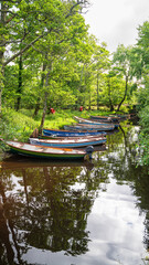 A row of small boats are floating in a river