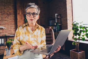 Photo of pretty senior female skeptical face hold netbook window wear formalwear coworking...