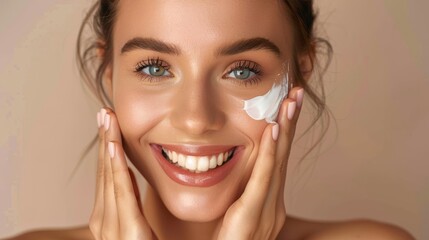 Young woman smiling while applying facial cream Close-up photo with clean background