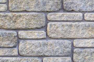Light brown and gray stone wall with light grout. Beautiful old stone pattern, background. Wallpaper