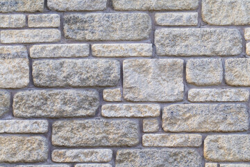 Light brown and gray stone wall with light grout. Beautiful old stone pattern, background. Wallpaper