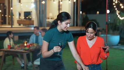 Family gather celebrate holiday. Focus Mother and grandmother drink wine and grill food for family...