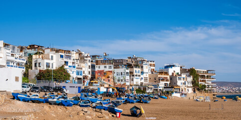 Taghazout, small fishing and surfing village with sandy beach, boats and traditional Moroccan buildings near Agadir, Morocco. Popular seaside resort among surfers