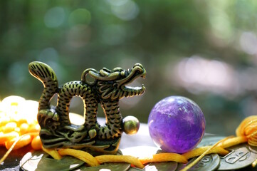 A rose quartz amethyst ball and a Chinese dragon figurine. Fortune telling and horoscope.